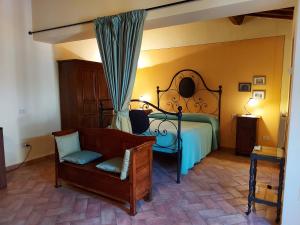 um quarto com uma cama e uma cadeira em Agriturismo Il Giovannello em Roccastrada