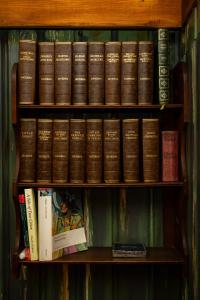 a book shelf filled with lots of books at Fagins Den Themed Holiday Cottage Broadstairs in Broadstairs