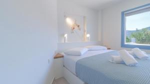 two beds in a white room with a window at Akasha Suite II in Vathi