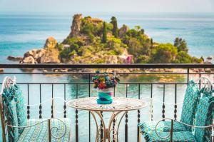 a table with chairs and a vase with flowers on it at Cohen Smart House in Taormina