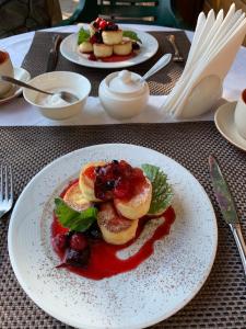 a plate of food with fruit and sauce on a table at ZarinSki in Kvasy