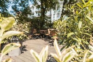 a wooden deck with chairs and plants in a garden at Wedina Serviced Apartments in Hamburg +26 photos