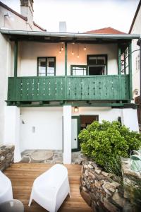 a house with a green balcony on a wooden deck at Domeček / Tiny House in Český Krumlov