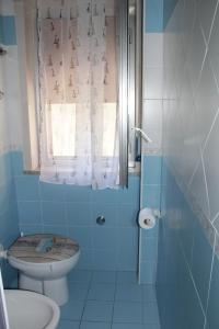 a blue bathroom with a toilet and a window at Holiday Beach in Milazzo