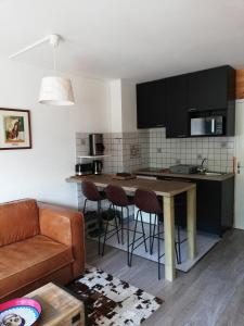 een keuken en een woonkamer met een tafel en stoelen bij Pra-Loup 1600, Front de Neige in Pra-Loup