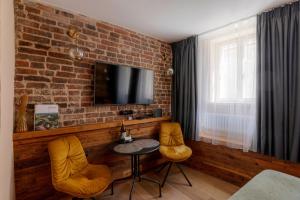 a room with a table and two chairs and a tv at Boutique Apartment Venezia Duo in Kuldīga