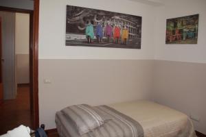 a bedroom with a bed and a painting on the wall at Holiday Beach in Milazzo