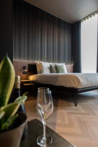 a bedroom with a bed and a wine glass on a table at Vinotel X in Tongeren