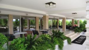 een lobby met tafels, stoelen en planten bij Kairos Resort & SPA in Piedimonte San Germano