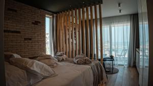 ein Schlafzimmer mit einem großen Bett und einer Ziegelwand in der Unterkunft COSea Living: SeaSide Deluxe Suite in Harbour 107B in Paphos City