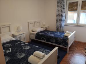 - une petite chambre avec 2 lits et une fenêtre dans l'établissement Monty Suite, à Rijeka