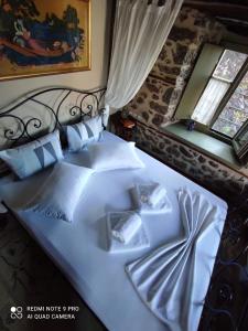 a bedroom with a large white bed with blue pillows at Bayiri Petit Pension in Litochoro
