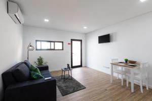 ein Wohnzimmer mit Sofa und Tisch in der Unterkunft As Casas da Margarida in Ribeira Grande