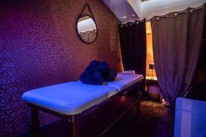 a room with a blue bench and a mirror at LOVE Suites & SPA "Le Loft" avec Jacuzzi privatif in Médis