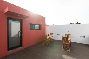 ein Zimmer mit Stühlen und einer roten Wand in der Unterkunft As Casas da Margarida in Ribeira Grande