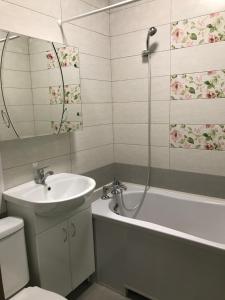 a bathroom with a sink and a tub and a toilet at Apartments O.Polya ( Kirova) 106 in Dnipro