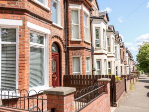 a row of brick houses with a wooden fence at Number 91 in Belfast