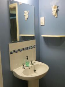 a bathroom with a sink and a mirror at Threeways House in Daventry