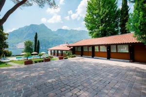 a house with a patio and mountains in the background at Villa Onedo in Abbadia Lariana
