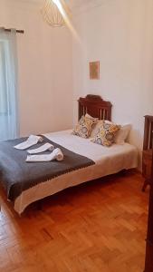 um quarto com uma cama e piso em madeira em Lanui Guest House em Sintra