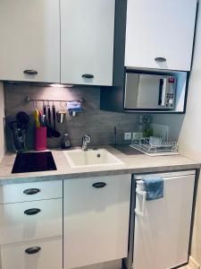 a kitchen with white cabinets and a sink at Gite des Carmes and Spa in Le Thor