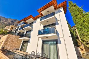 a large white building with tables in front of it at Happy Kaş Apart in Kaş