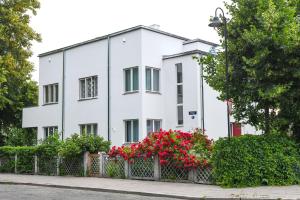 a white building with red flowers in front of it at Zagorski Apartment 2 in Kuressaare