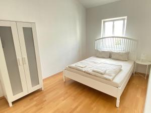 1 dormitorio con cama blanca y ventana en Vienna Living Apartments - Rustengasse, en Viena