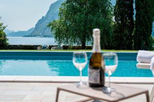 a bottle of wine sitting on a table with two wine glasses at Villa Onedo in Abbadia Lariana
