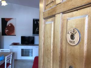 een houten deur met een bord waarop staat: bij House Turi in Ardea