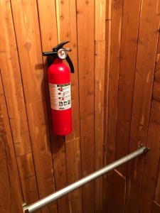 una boca de incendios roja colgada en una pared de madera en Newhouse Family Inn en Lewisville