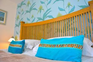 a bed with two blue pillows on top of it at No12 Bed and Breakfast, St Andrews in St Andrews