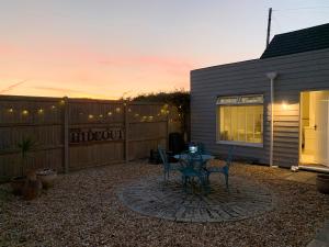 a patio with a table and chairs and a fence at The Hideout in Chichester