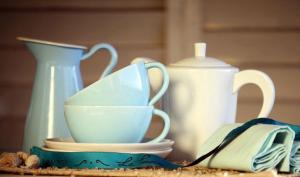 una mesa cubierta con tazas y platos y un hervidor de agua. en Hotel Boutique La Perouse, en Hanga Roa