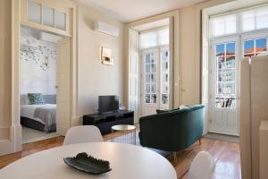 een woonkamer met een bed en een tafel en stoelen bij Historic apartment at Cardosas with balcony in Porto