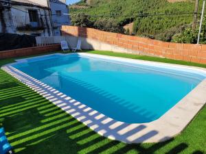 a swimming pool in the yard of a house at Casa Rural Abuelo Flore in Caminomorisco