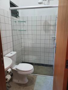 uma casa de banho com um WC e uma cabina de duche em vidro. em Suite 03 - Independente, privativa e aconchegante em Cuiabá