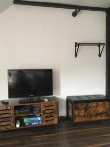 uma sala de estar com uma televisão de ecrã plano e um banco em Miejscówka w Narnii em Budzów