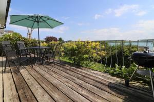 a deck with a table and chairs and an umbrella at Holiday home with Estuary Views, parking & balcony in Padstow