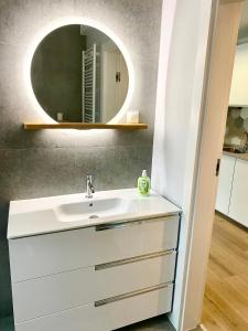 a bathroom with a sink and a mirror at Apartament LEA in Międzywodzie
