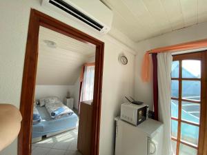バラトンフェニヴェシュにあるEmma Villaのベッド1台、電子レンジが備わる小さな客室です。