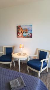 um quarto com duas cadeiras, uma mesa e um quadro em Apartament Mandree em Costinesti