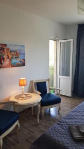 um quarto com uma mesa e duas cadeiras e uma mesa e uma janela em Apartament Mandree em Costinesti