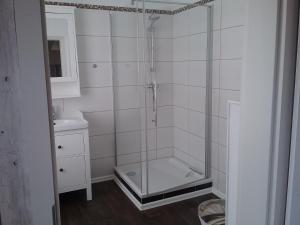 La salle de bains est pourvue d'une douche avec une porte en verre. dans l'établissement Fischerhaus König in Alt Sassnitz, à Sassnitz