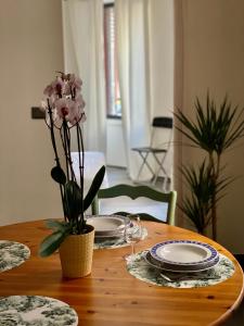 einen Tisch mit Platten und eine Vase mit Blumen darauf in der Unterkunft Le Pont Kuss in Straßburg