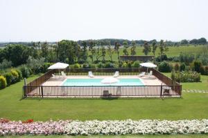 uma piscina no meio de um campo com duas cadeiras em Casa Vacanza Il Malandrone em Vada