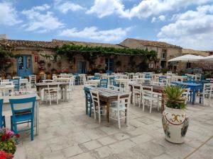 a patio with tables and chairs in front of a building at LiMonello Marzamemi in Marzamemi