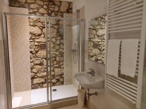 La salle de bains est pourvue d'un lavabo et d'une douche avec une porte en verre. dans l'établissement Appartamento grazioso in palazzina del 900: Verona, à Vérone