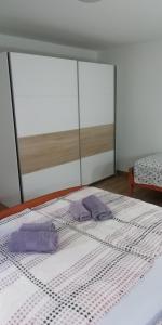 奧托查茨的住宿－Apartman Luce，床上有两条紫色毛巾