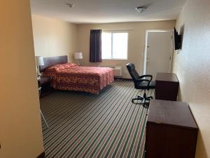 a hotel room with a bed and a desk and a chair at Wayne Motel in Fort Wayne